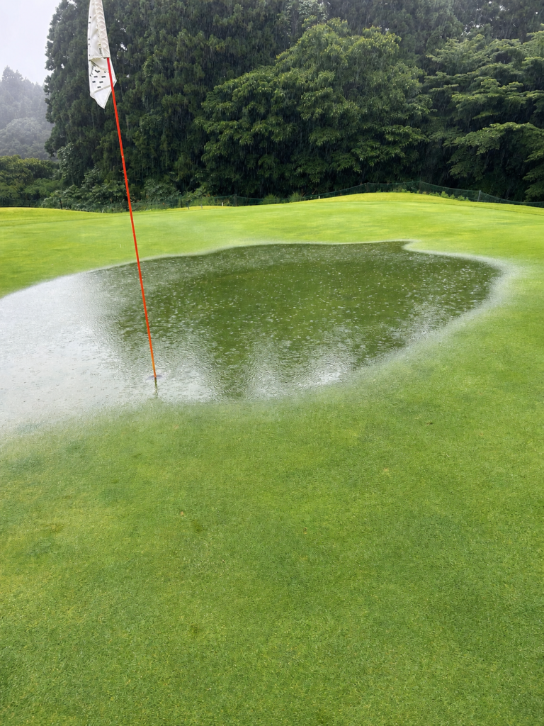 大雨で水たまりができたコスギリゾート阿蘇ハイランドのグリーン