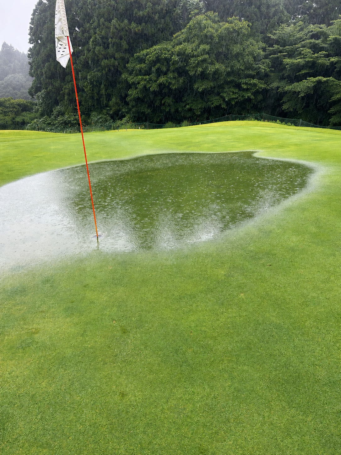 大雨で水たまりができたコスギリゾート阿蘇ハイランドのグリーン